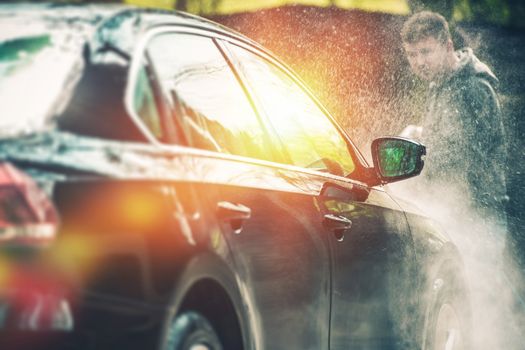 Car Washing and Cleaning. Young Caucasian Men Washing His Car.