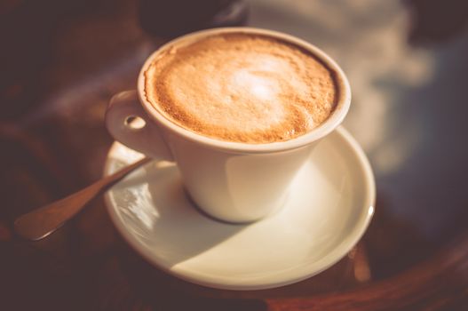 Fresh Tasty Cup of Coffee Closeup Photo. Coffee Cup on Glassy Table.