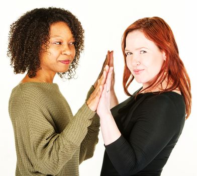 Two grinning friends touching their palms over white background