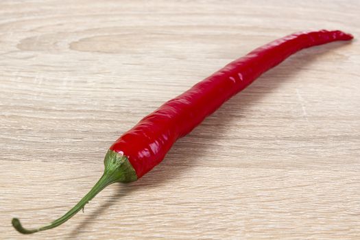Red hot chilli pepper on a wooden background