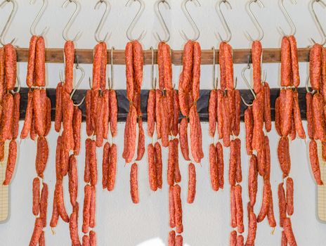 Various smoked sausage or salami in a butcher shop on meat hook.