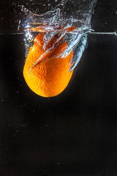 Orange splashing with in water.