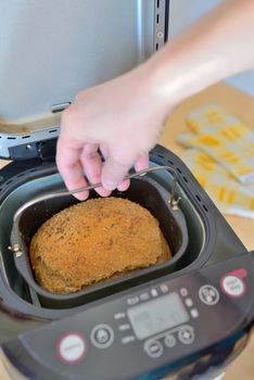 Bread machine with pan and fresh bread at home