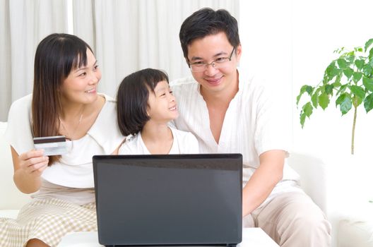 Asian family using laptop to perform online shopping