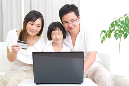 Asian family using laptop to perform online shopping