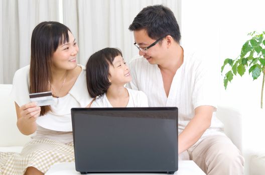 Asian family using laptop to perform online shopping