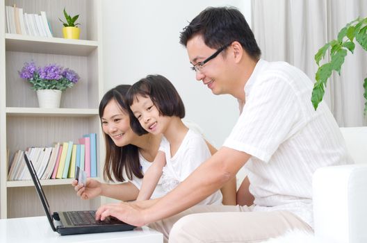 Asian family using laptop to perform online shopping