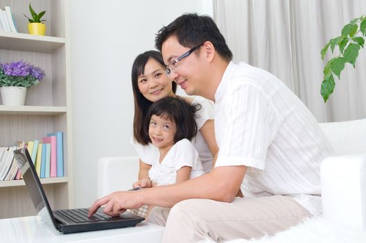 Asian family using laptop to perform online shopping