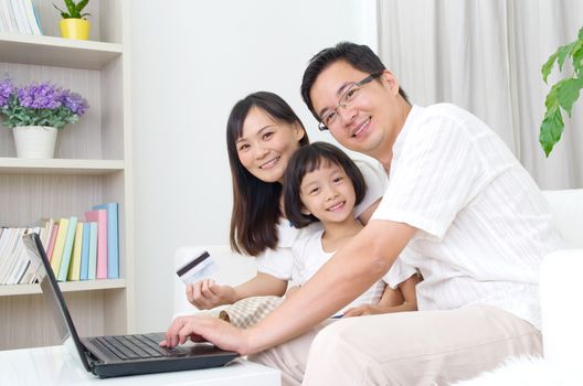 Asian family using laptop to perform online shopping