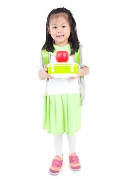 Asian primary school girl holding lunch box and apple. Healthy eating concept for schoolchild.