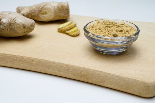 Ginger root, slices and powder on a white background