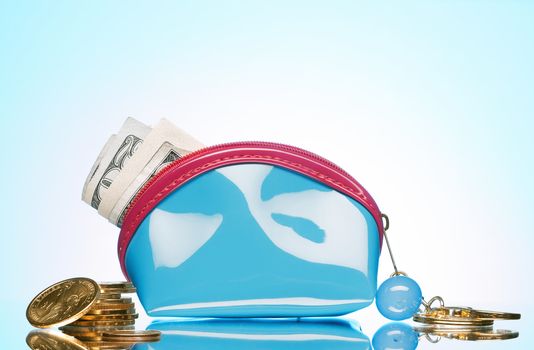 close up view of blue purse filled with cash on color back