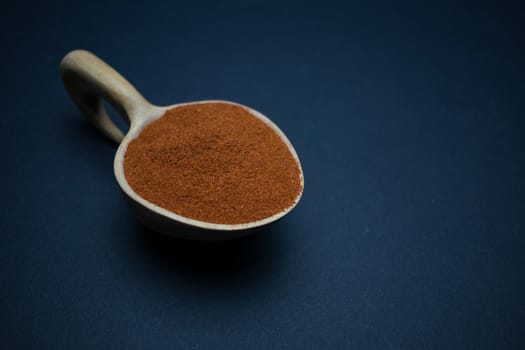 paprika powder disposed on a wooden spoon