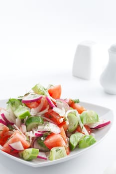 close up view of fresh vegetable salad on white background