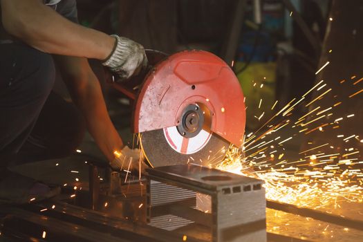 Men use Electric grinder on a workshop.