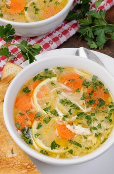 Homemade, tender soup with chicken, lemon, orzo, and fresh parsley leaves