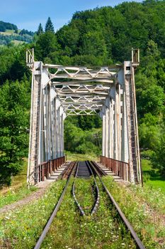 old white rusty metal rail road bridge in mountains