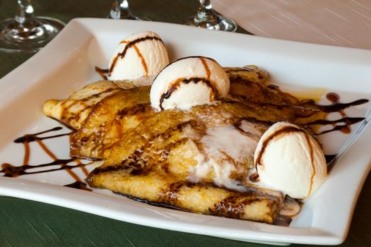 Sweet dessert, Parisian pancakes with ice cream honey and chocolate on a white plate