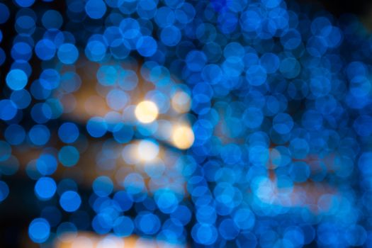 abstract background of blurred cool blue lights with warm yellow spots with bokeh effect