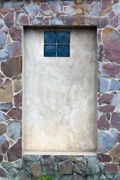 frame in the wall is made of pieces of stone with window inside