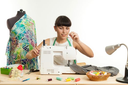 the woman the tailor sews clothes on the sewing machine