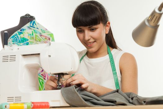 the woman the tailor sews clothes on the sewing machine