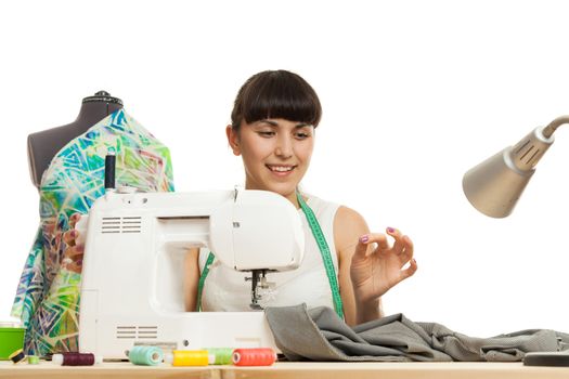 the woman the tailor sews clothes on the sewing machine