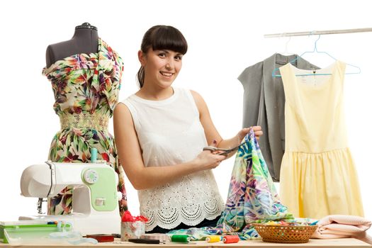 the woman the tailor on a white background behind production of clothes