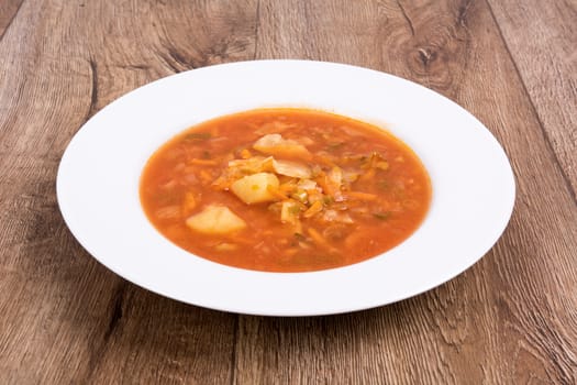 Vegetarian vegetable soup on a wooden table