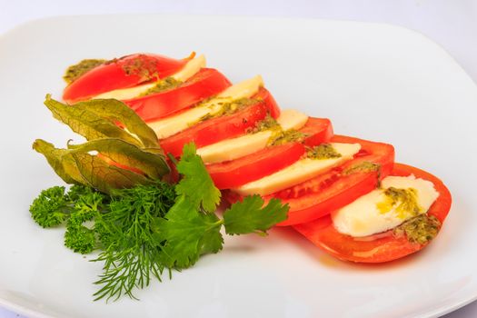 Greek classic summer salad of red big juicy tomatoes cutting circles to 2 millimeters, fresh and soft goat cheese feta sauce of special herbs, served with parsley, dill and fezalis