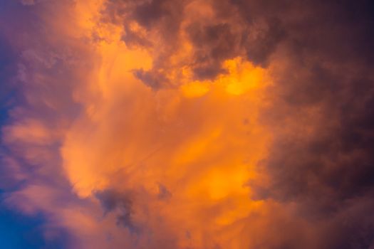 Ominous sky plays with light. sky becomes dark purple clouds. yellow-orange light from the sun breaks through the storm.