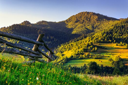 wooden fence in the grass on the hillside