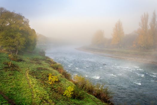 beautiful view of the boiling autumn river in the morning mist