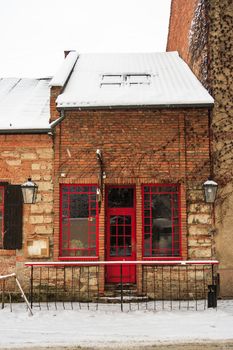 old pub with red windows and a door in winter