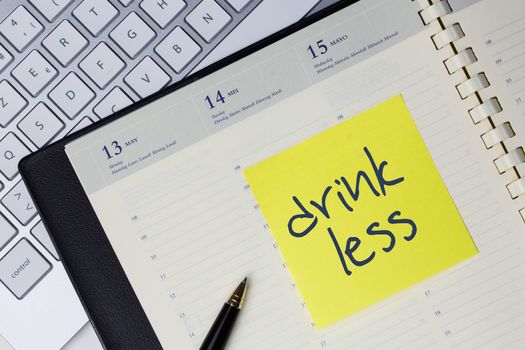 Paper note with the words - Drink less - in business desk. How to get better concept