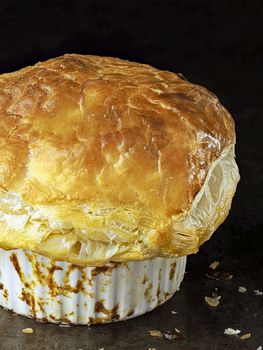 close up of rustic golden english meat pot pie with flaky crust