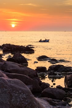 Two fishermen on the boat go fishing at sea in the morning sun