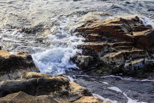 sea ​​wave attacks the boulders and is broken about them