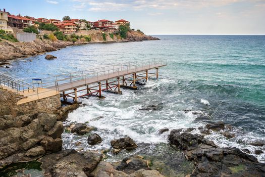 metal pier on the rocky shore near the old sea town