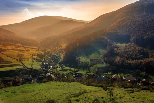 sunrise in small village at the foot of a  mountain