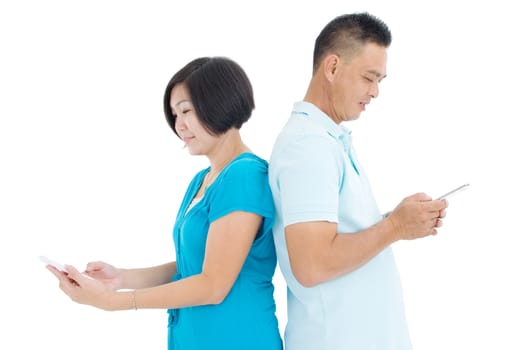 Asian Middle couple playing with smartphones instead of conversation