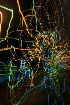 abstract curves traces of multi-colored trails of light on a dark background look like a spider web