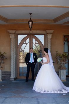 Stylish newlyweds posing against the retro door