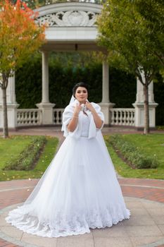 Bride on promenade in summer park posing on photo