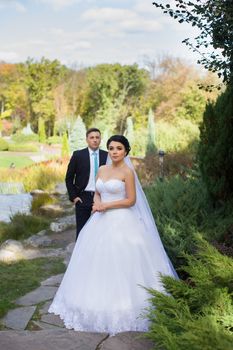 The groom tenderly embraced the happy bride in the summer park