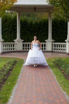 Bride on promenade in summer park posing on photo