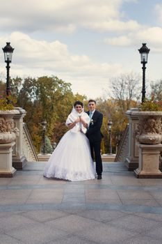 The groom tenderly embraced the happy bride in the summer park