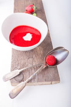 Strawberry soup with a spoon on a table