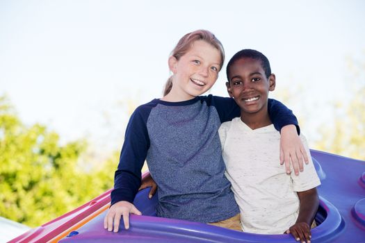 Laughing cheerful boy with cute adopted brother embracing outside