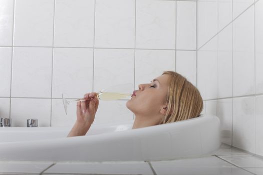 blonde woman in a bathtube with champagne